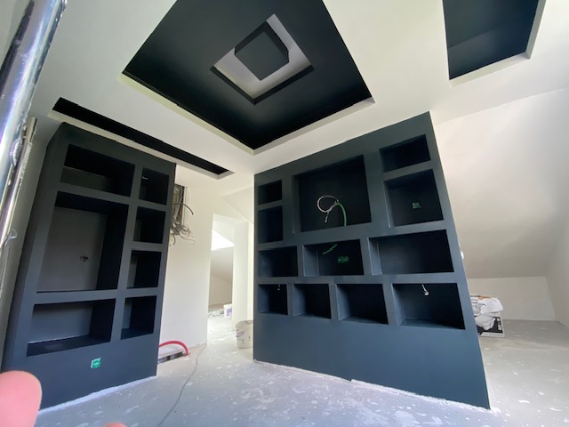 Rangements anthracite et plafond décoratif dans un intérieur rénové
